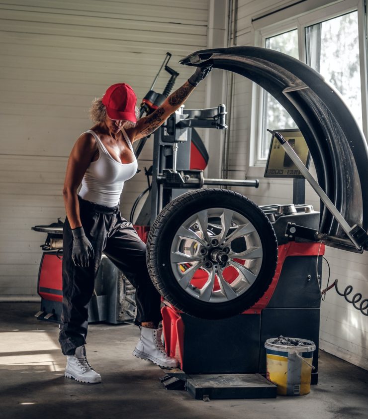 Woman is fixing part of broken car