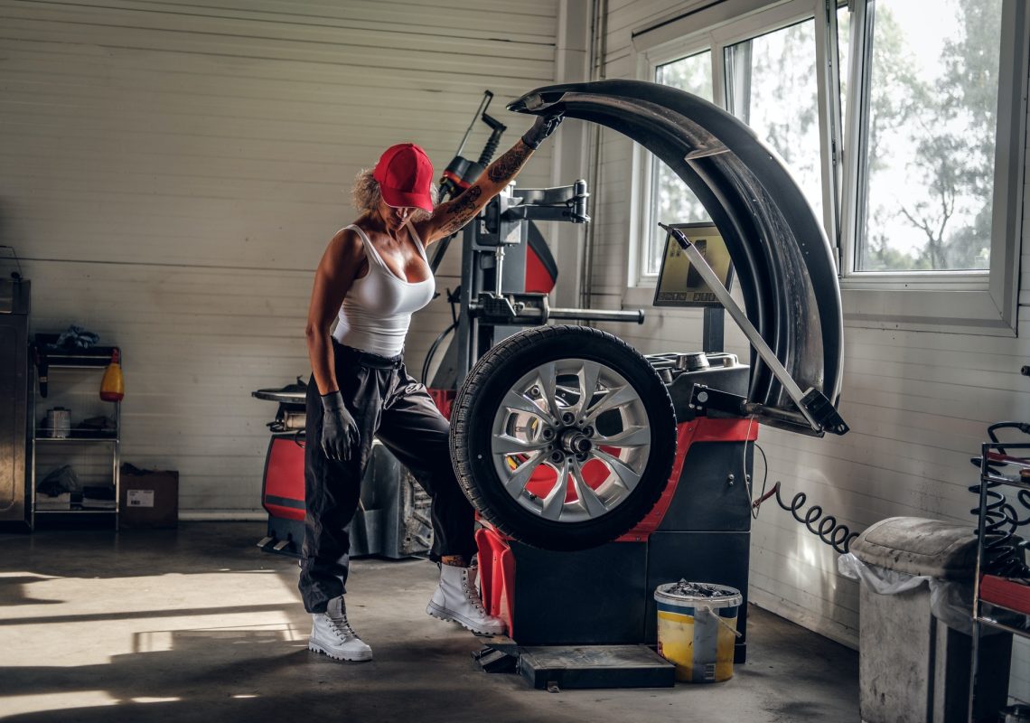 Woman is fixing part of broken car